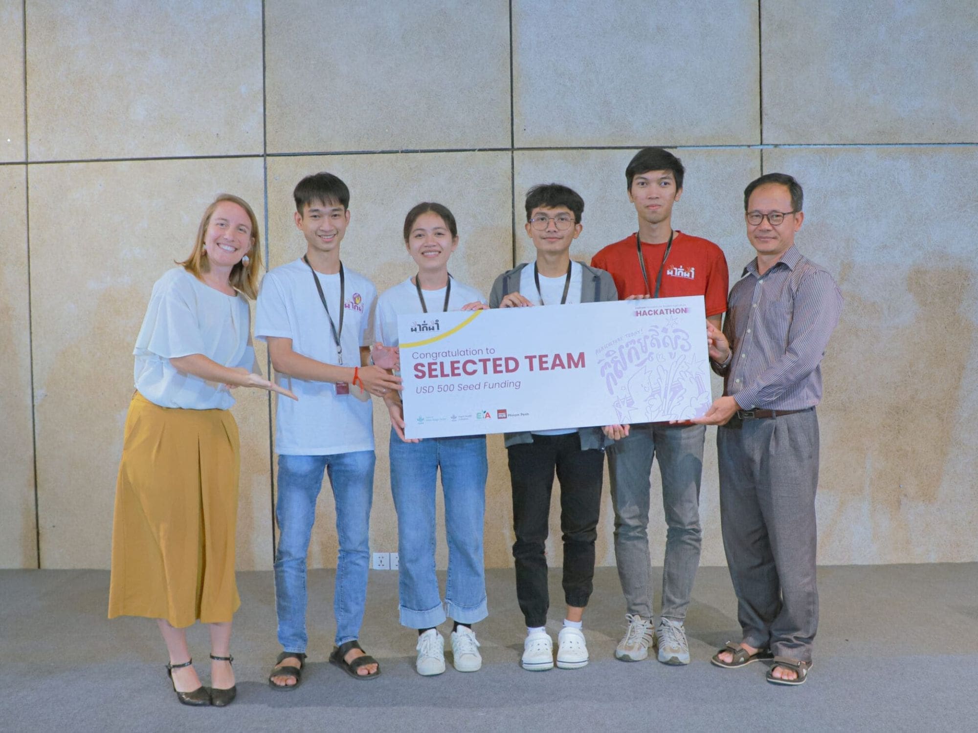 Members of the team CamboGreens pose with their mentors at the end of the DakDam hackathon.