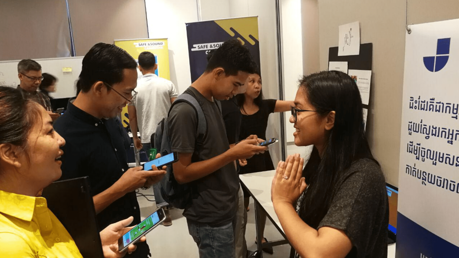 A small group of people talk with a representative of Jidser at a booth showcasing the venture.