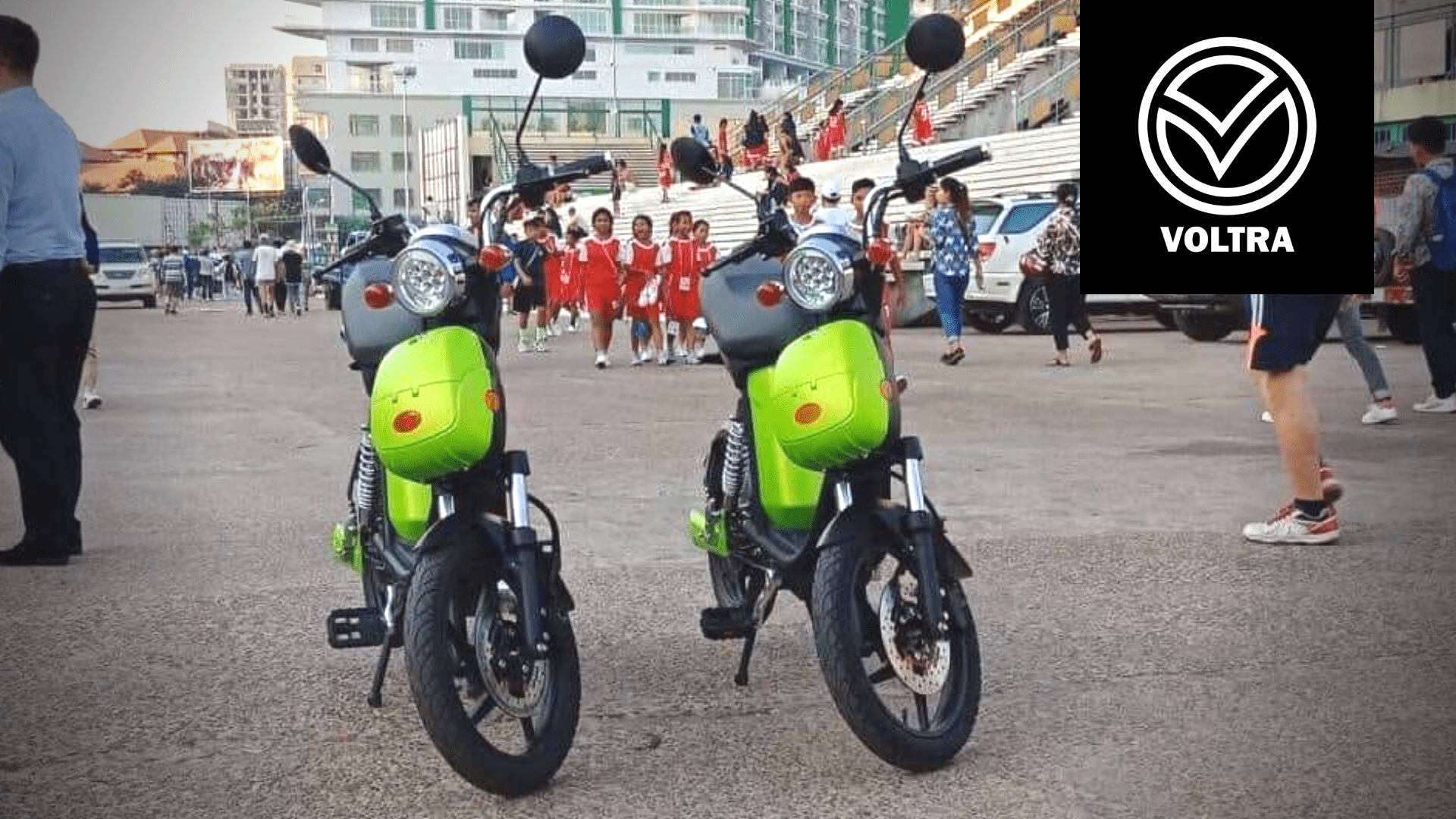 Two lime green Voltra e-motorbikes on a street in Phnom Penh.