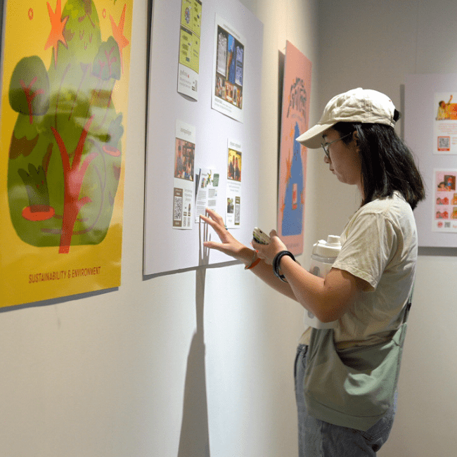 Young female with white hat concentrate on content gallery of Prosob Exhibition in Cambodia