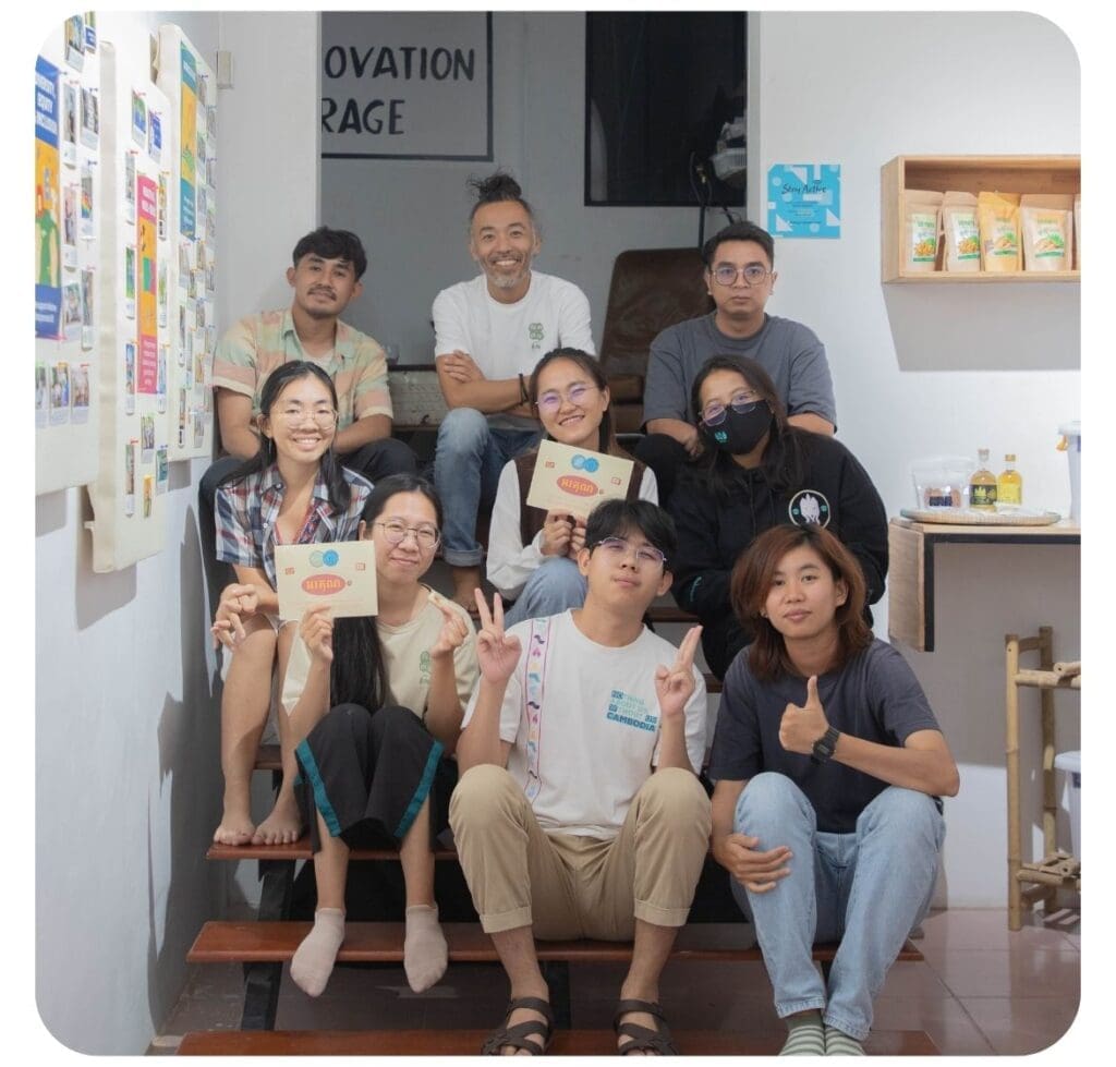 A small group of content creators and Impact Hub staff sit on a staircase smiling and posing for a photo after a media4impact event.