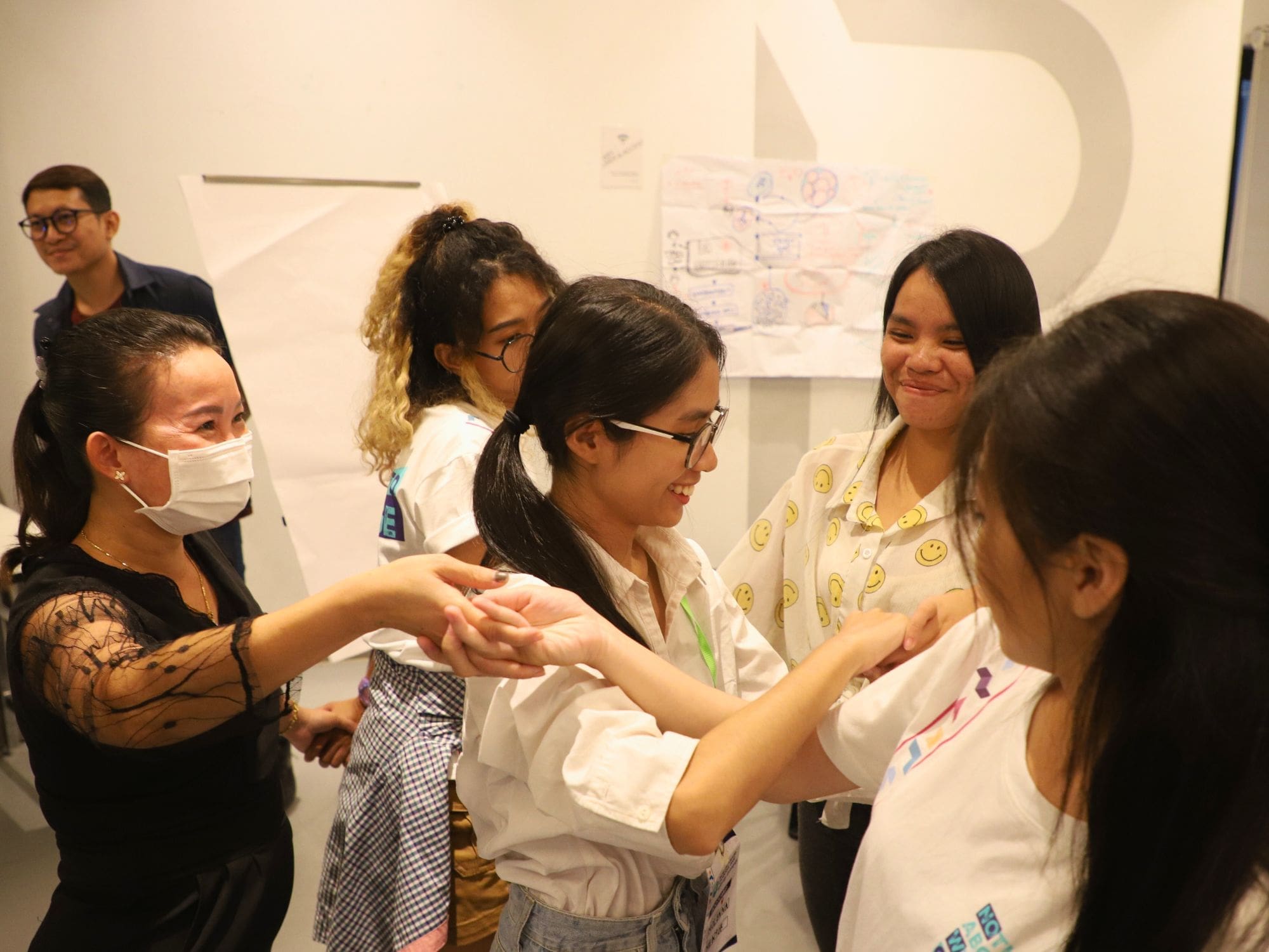 A group of young Cambodians stand and do an icebreaker activity during the Now-Us Awards program bootcamp.