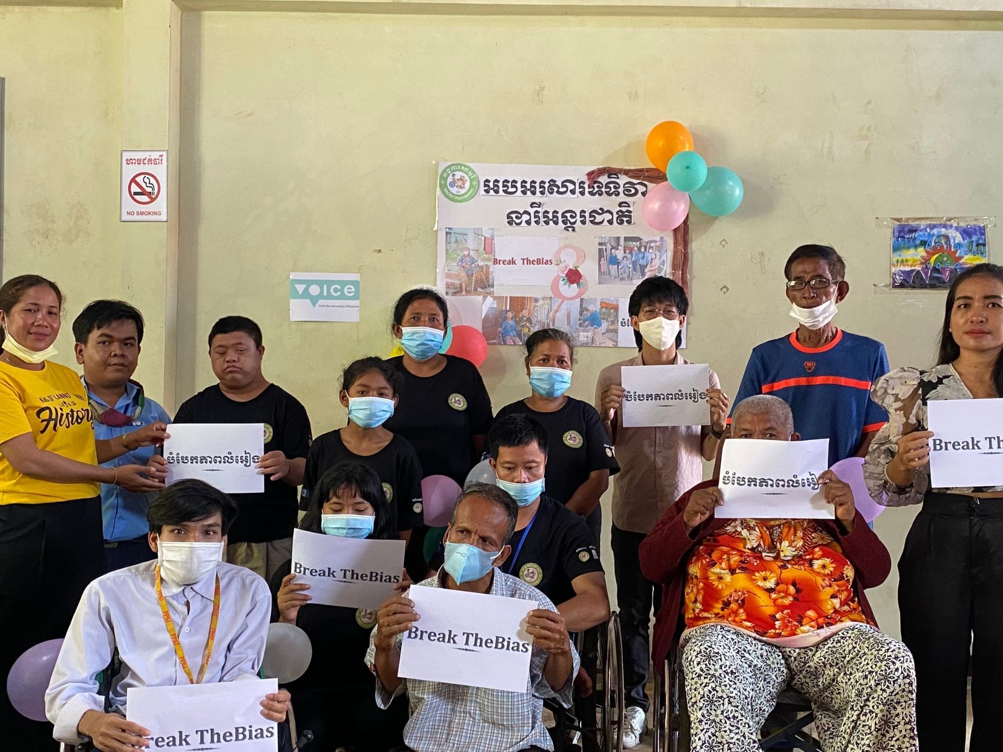 A group of people stand holding signs as part of SAORI organization.